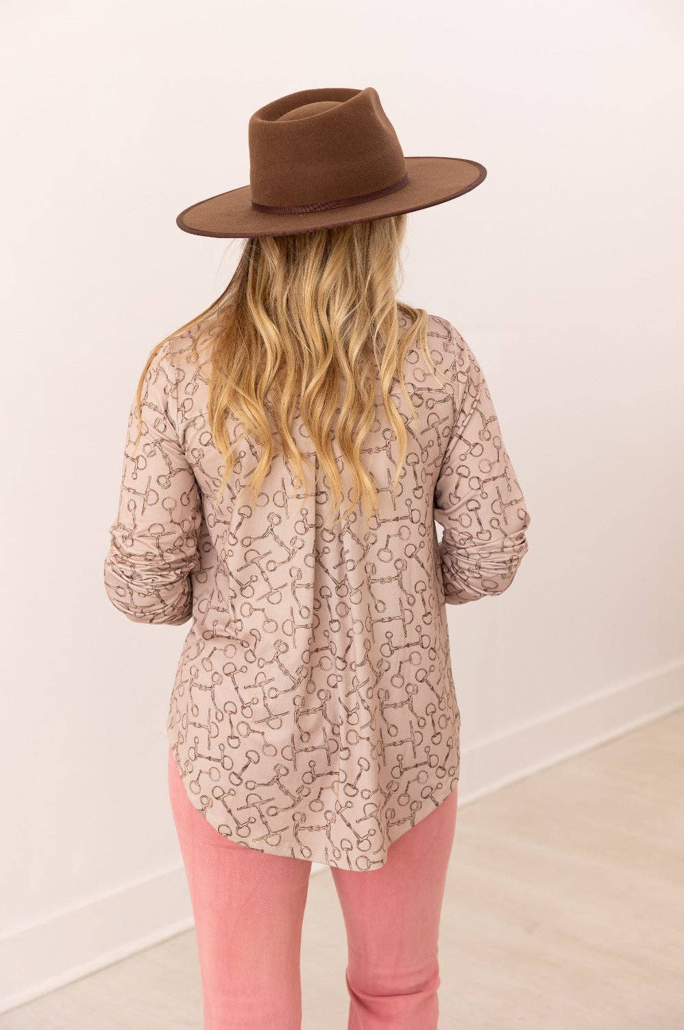 Back view of V-neck stretch top with roll-tab sleeves in a relaxed fit tan with brown horse bit pattern all over top