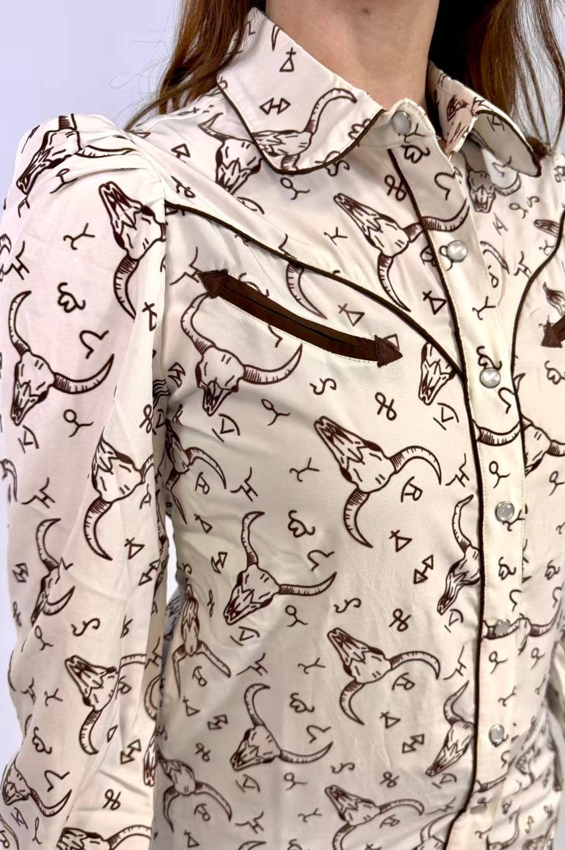Person wearing a patterned shirt with longhorn bull design on a light background