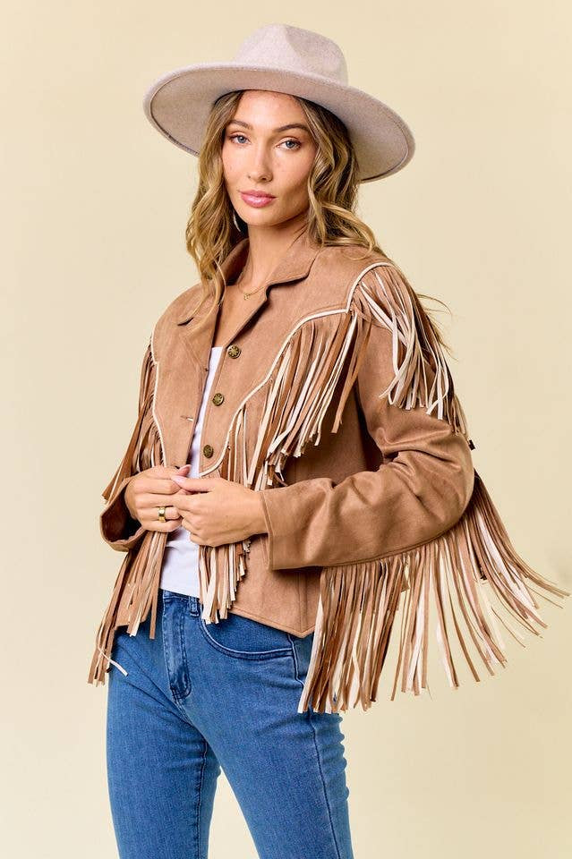 Woman wearing a tan fringe jacket and hat on a beige background