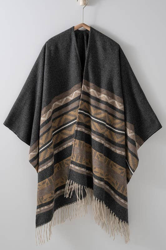 Dark gray poncho with brown and beige striped pattern and fringes on a white background