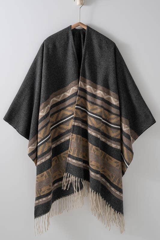 Dark gray poncho with brown and beige striped pattern and fringes on a white background