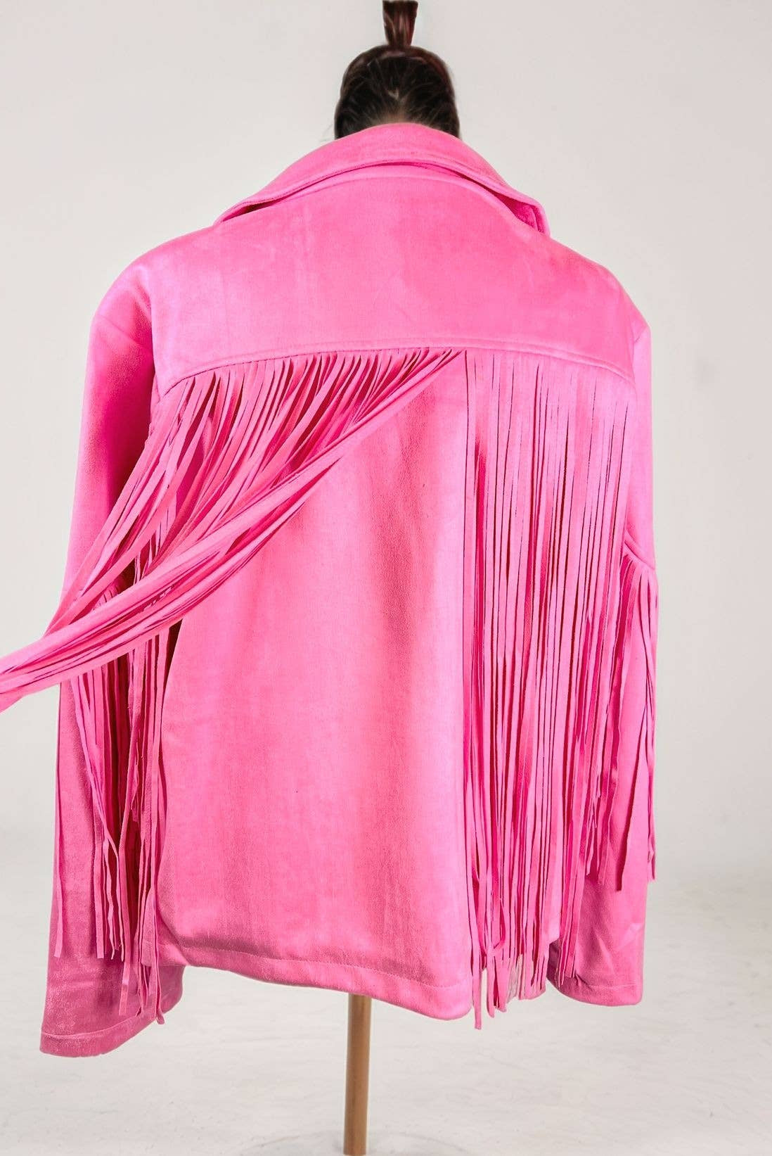 Pink fringed jacket on a mannequin against a white background