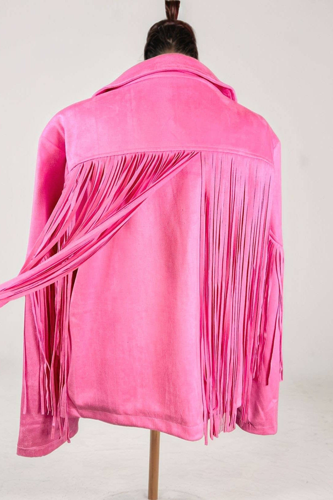 Pink fringed jacket on a mannequin against a white background