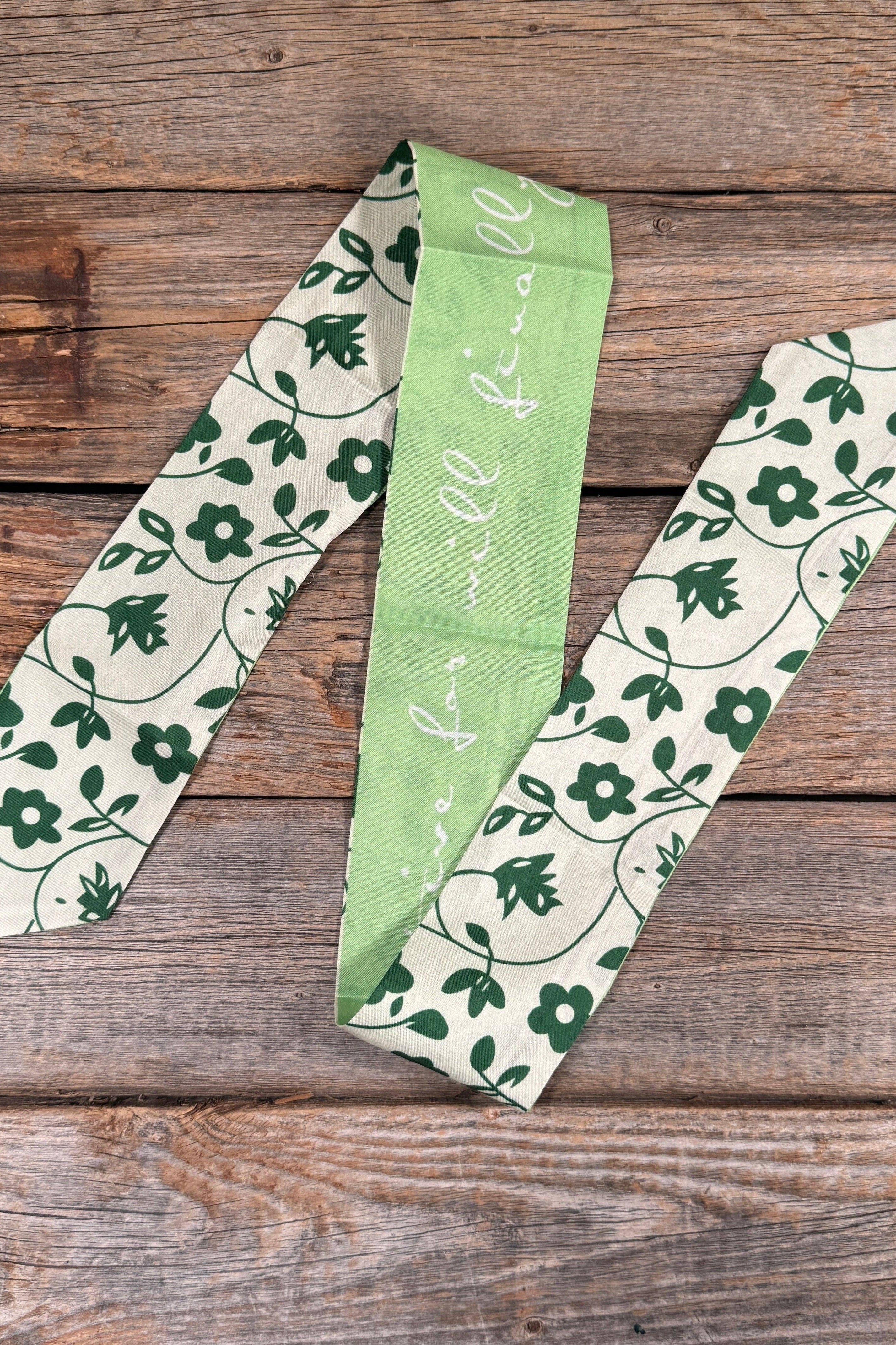Three green and white patterned ribbons on a wooden surface