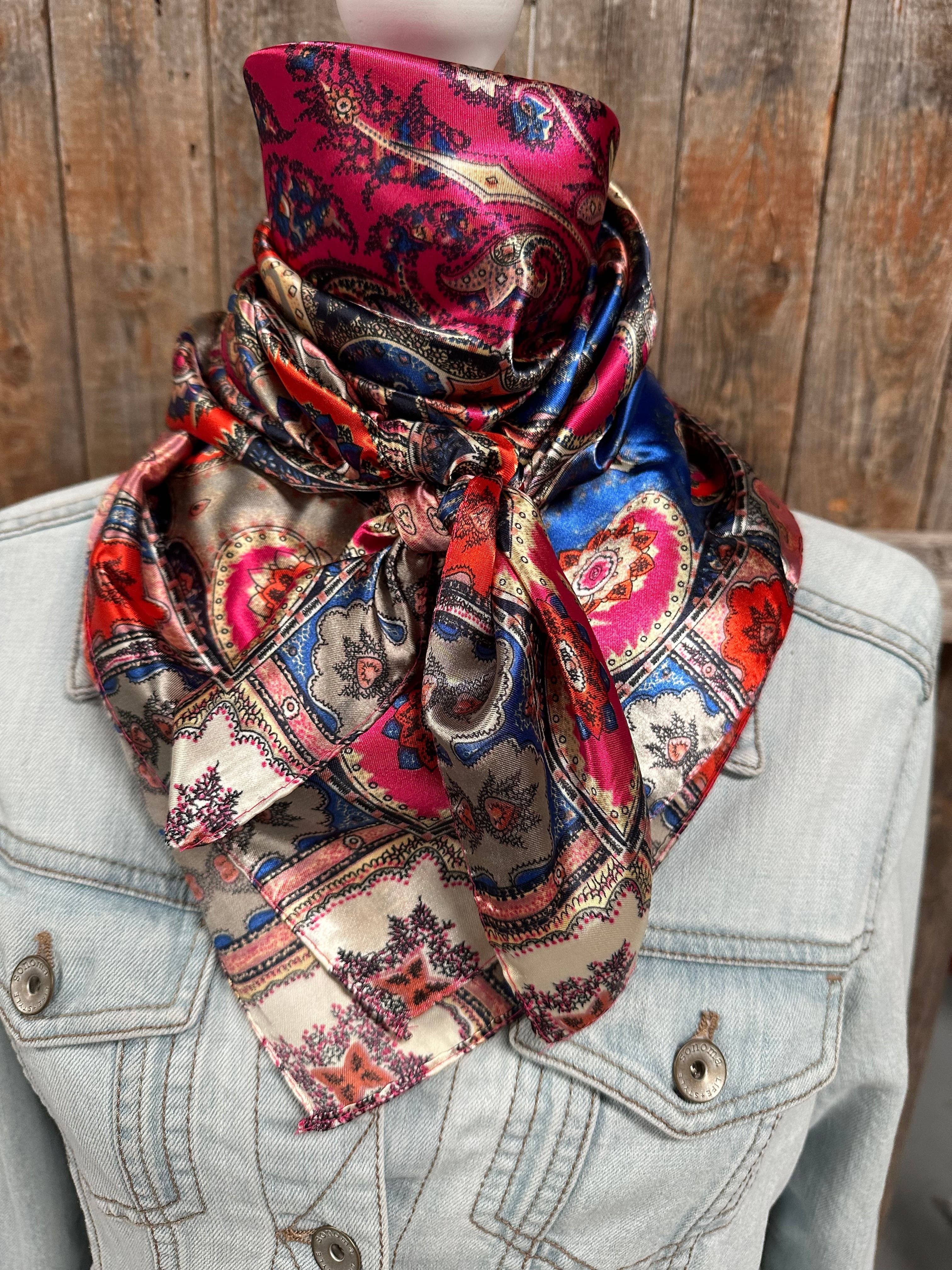 Colorful patterned scarf draped over a denim jacket against a wooden background