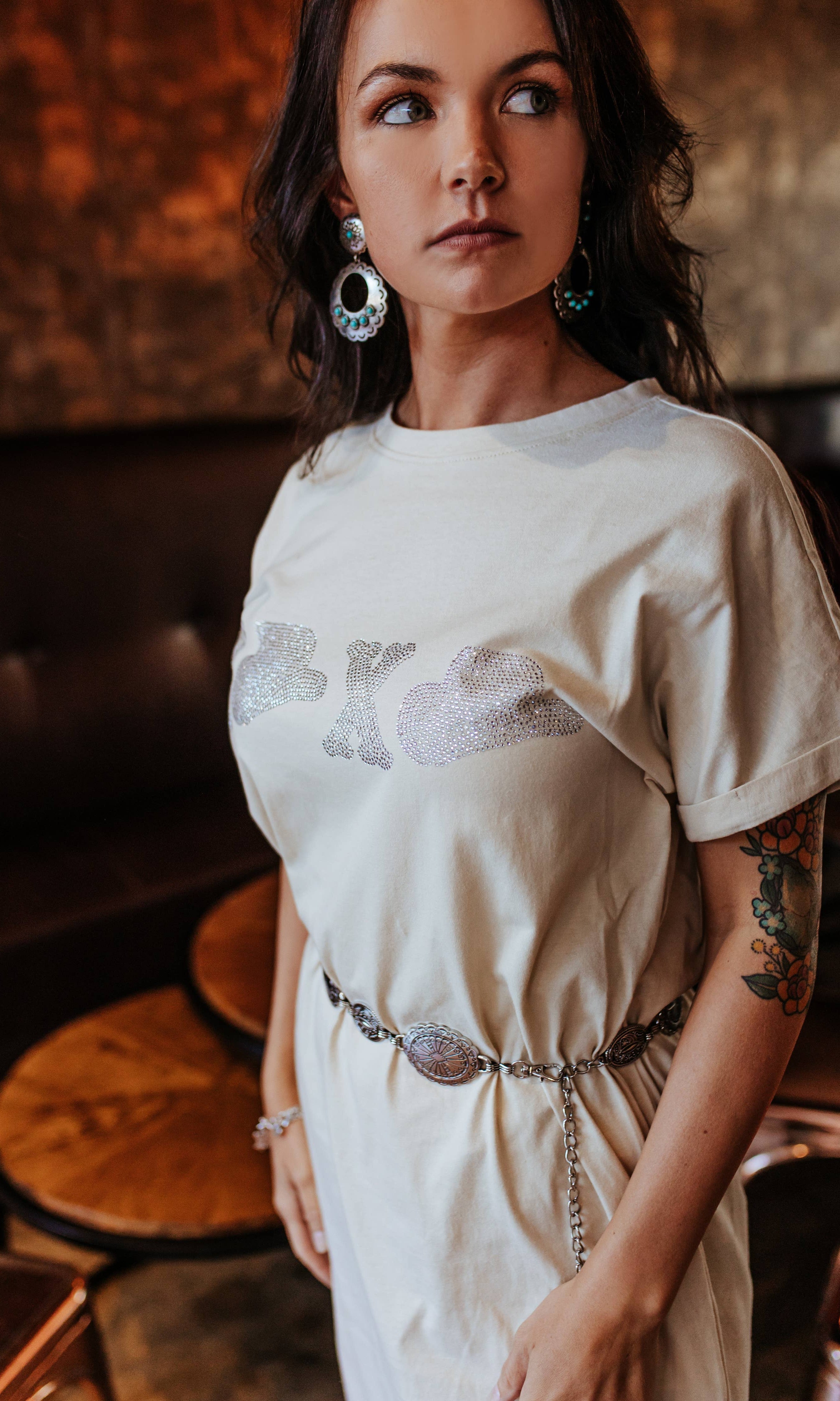 Woman wearing a white dress with floral patterns in an indoor setting