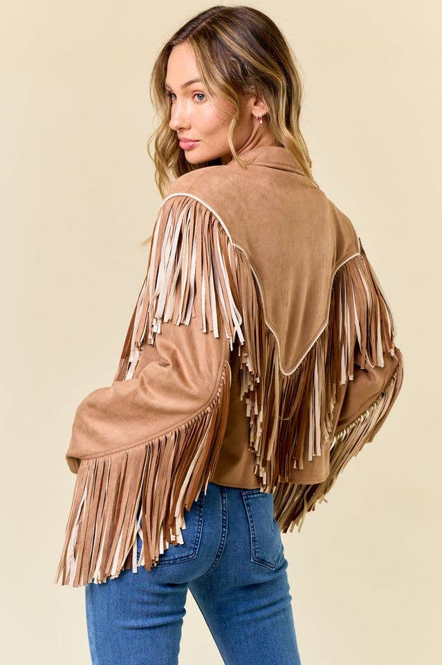 Woman wearing a brown suede fringe jacket on a beige background