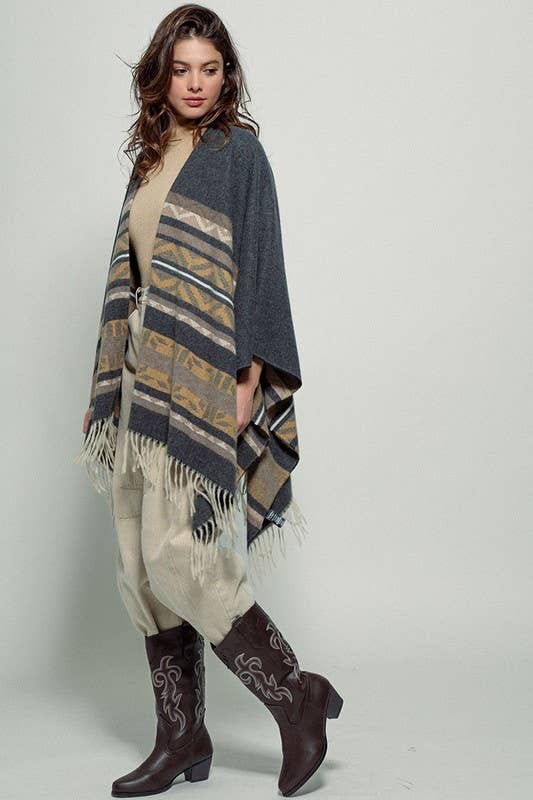 Dark gray poncho with brown and beige striped pattern and fringes on a white background