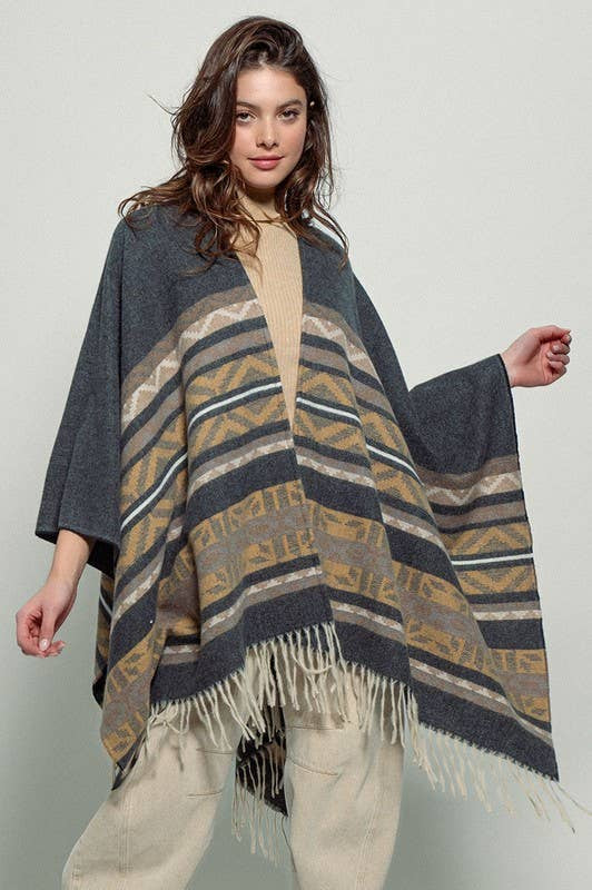 Dark gray poncho with brown and beige striped pattern and fringes on a white background