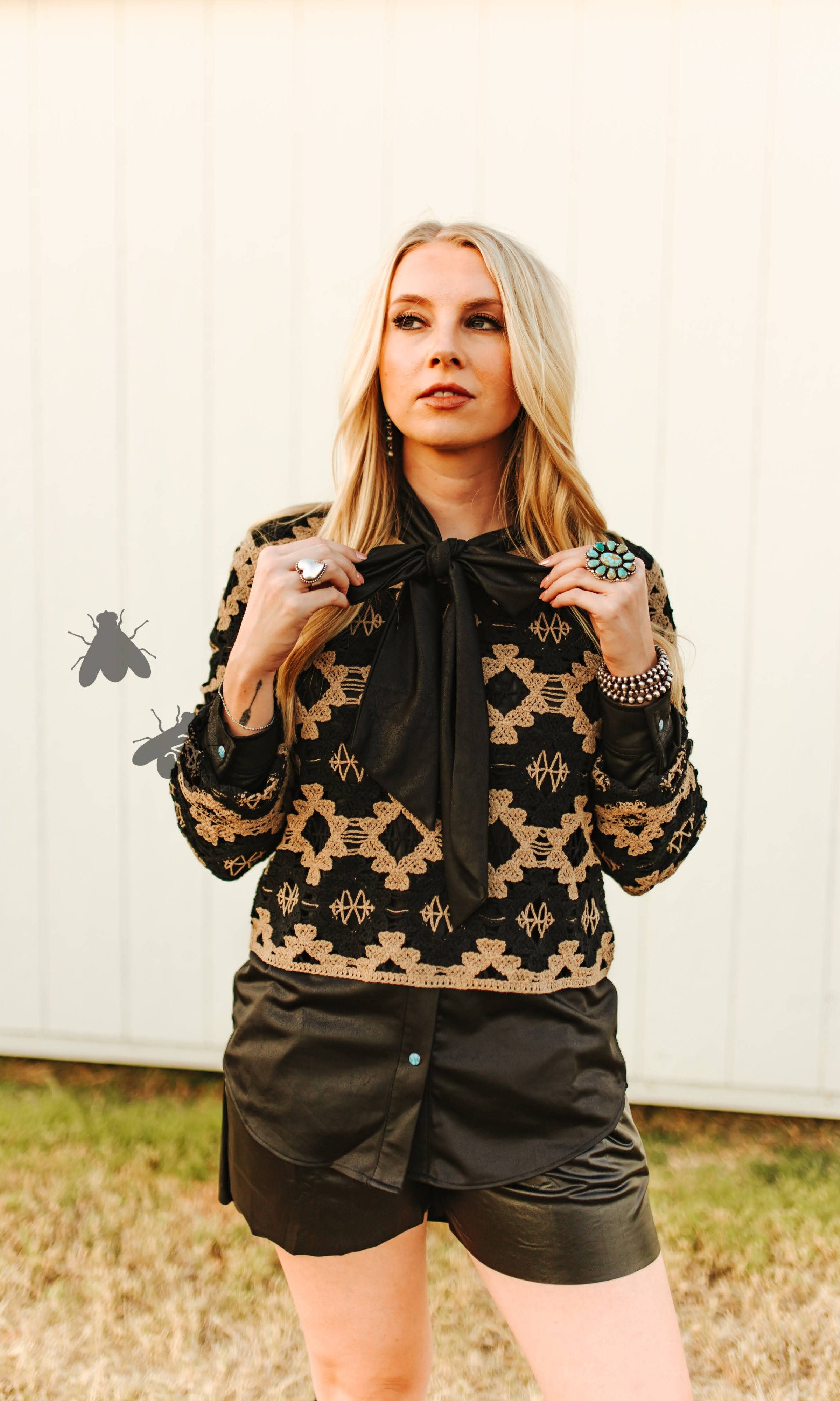 Woman wearing a patterned top with a bow tie in an outdoor setting