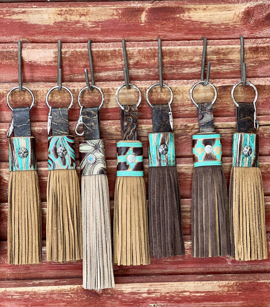Handmade leather keychain with tassel and concho details.