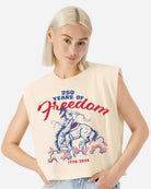 Person wearing a  cream sleeveless tee shirt with '250 Years of Freedom' bucking horse design on a white background
