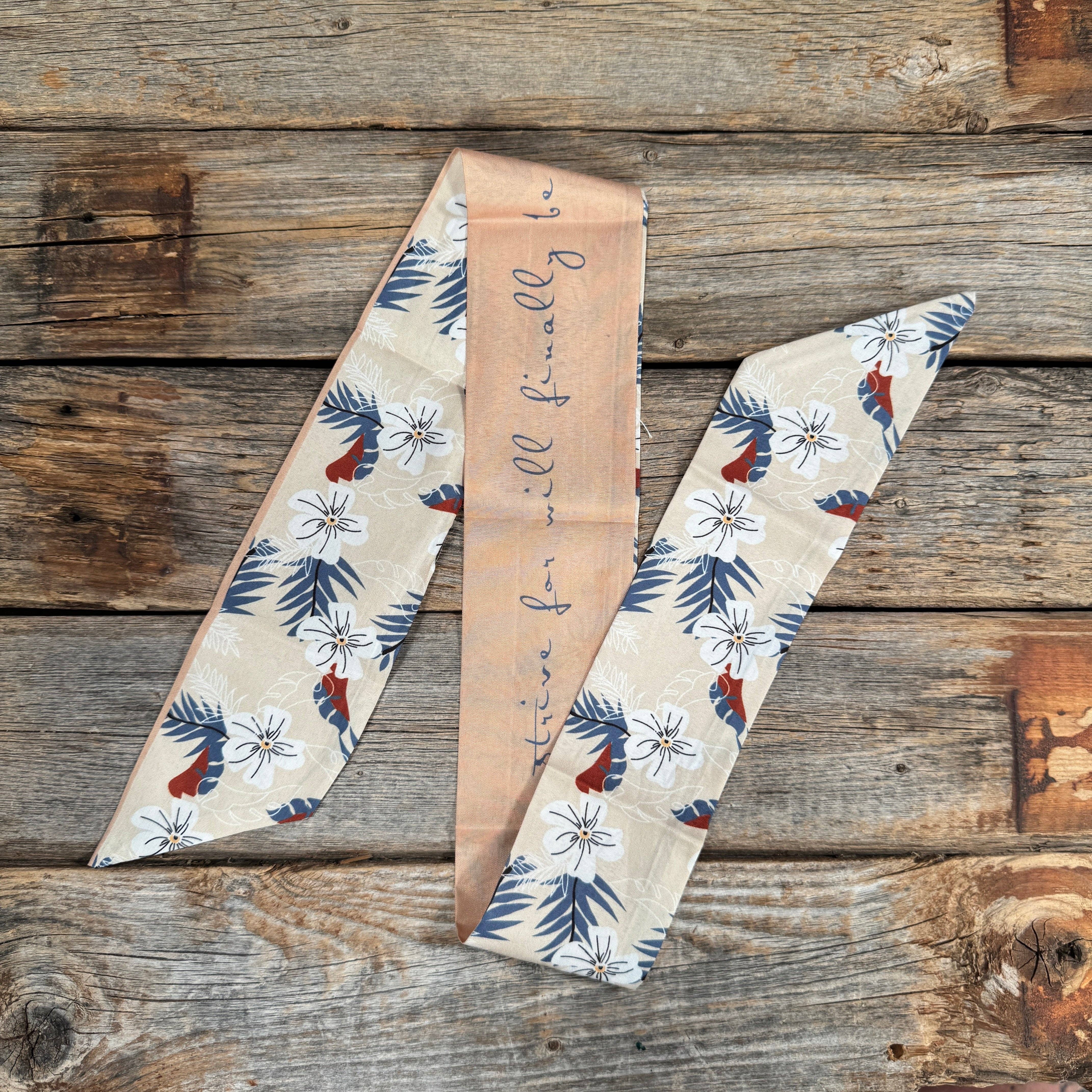 Decorative fabric scarf with floral patterns on a wooden surface