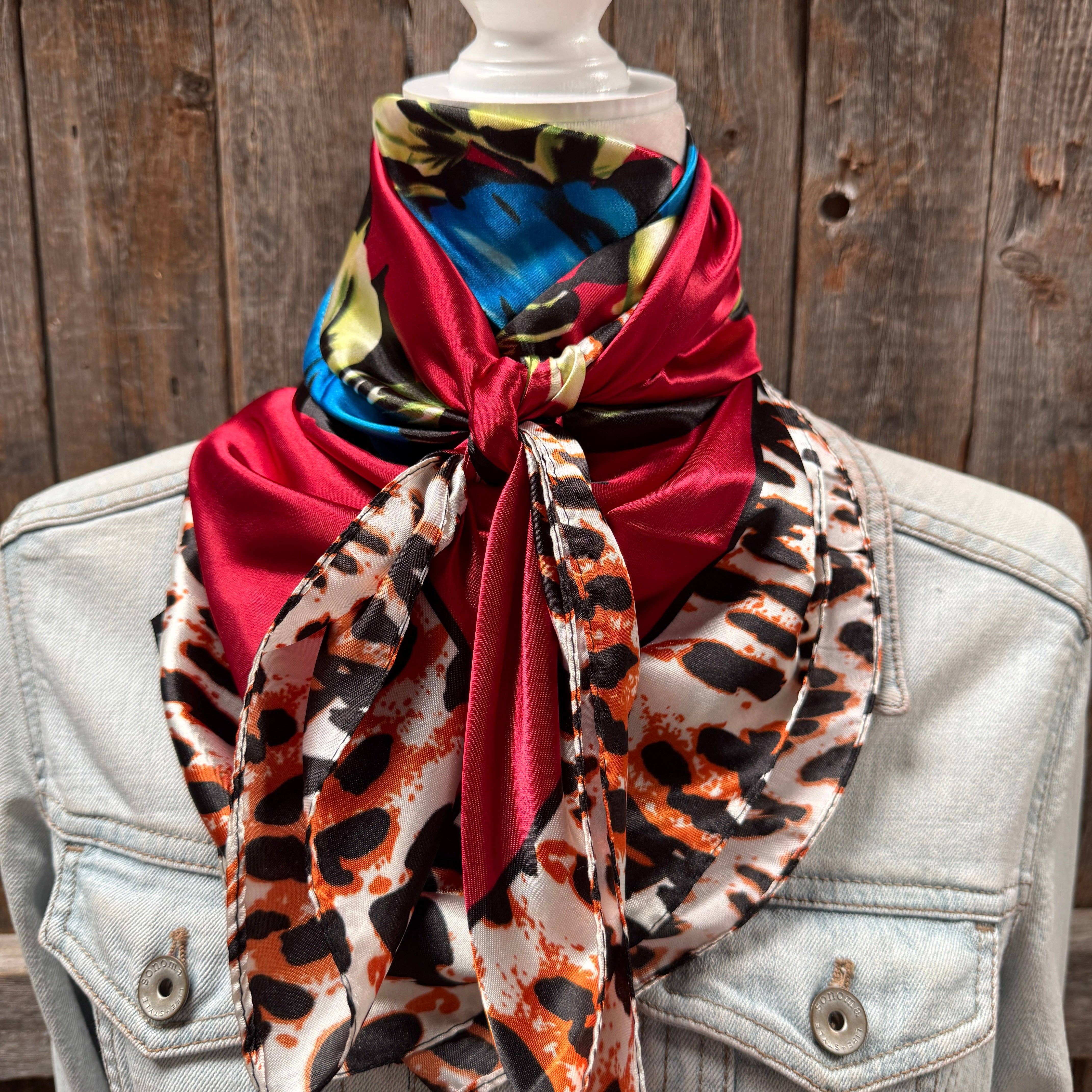 Colorful scarf with animal print draped over a denim jacket against a wooden background