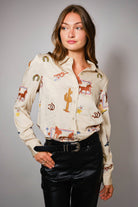 Woman wearing a western embroidery patterned shirt with a plain background