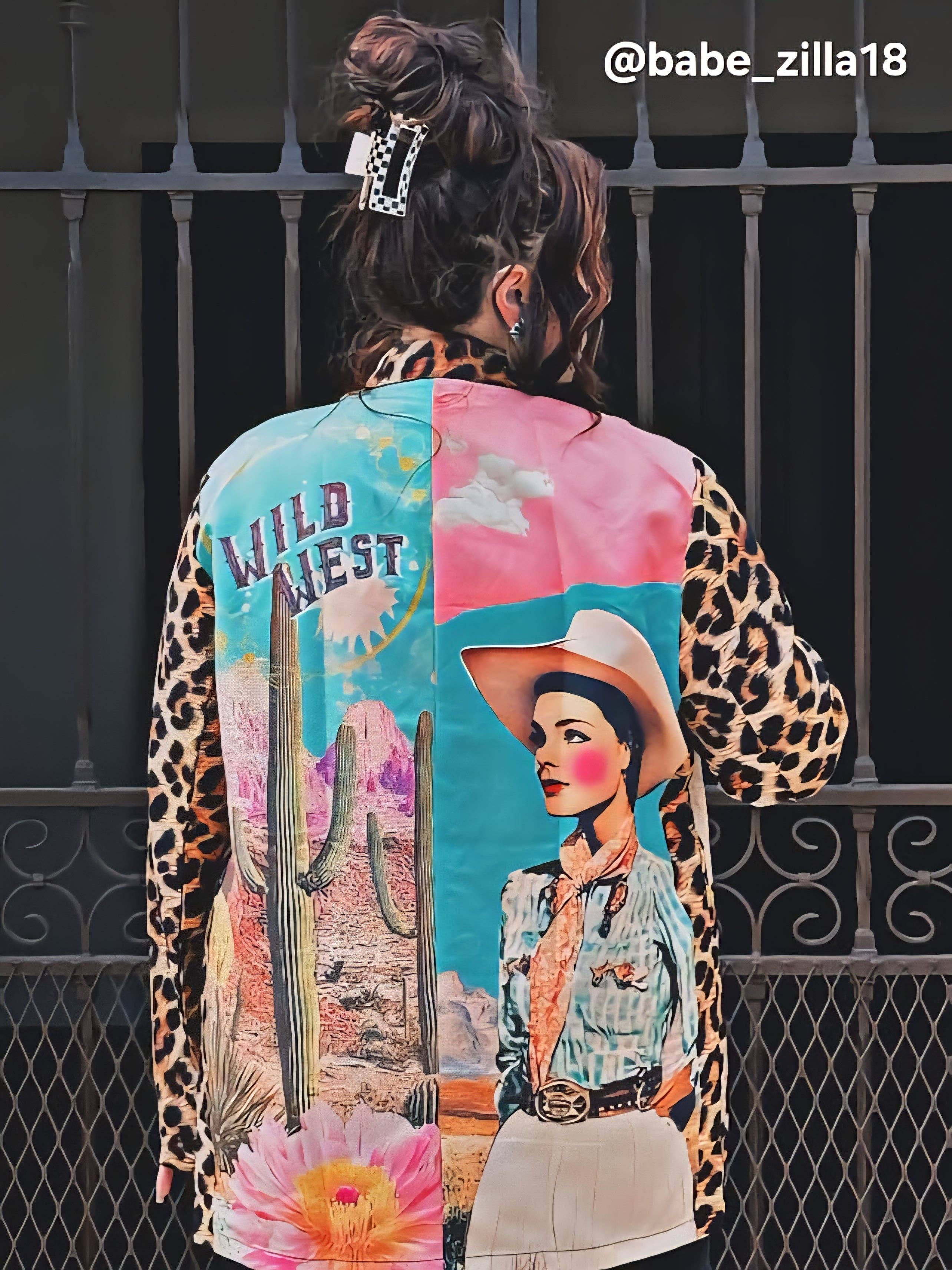 Person wearing a colorful jacket with artistic designs and text.