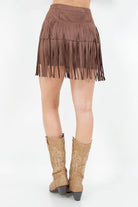 Brown fringe skirt and tan cowboy boots on a white background