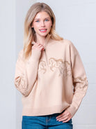 Taupe high-neck quarter-zip sweater with horse embroidery on model, front view.