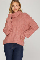 Front view of rosy-rust cable knit turtleneck sweater with ribbed cuffs and hem.