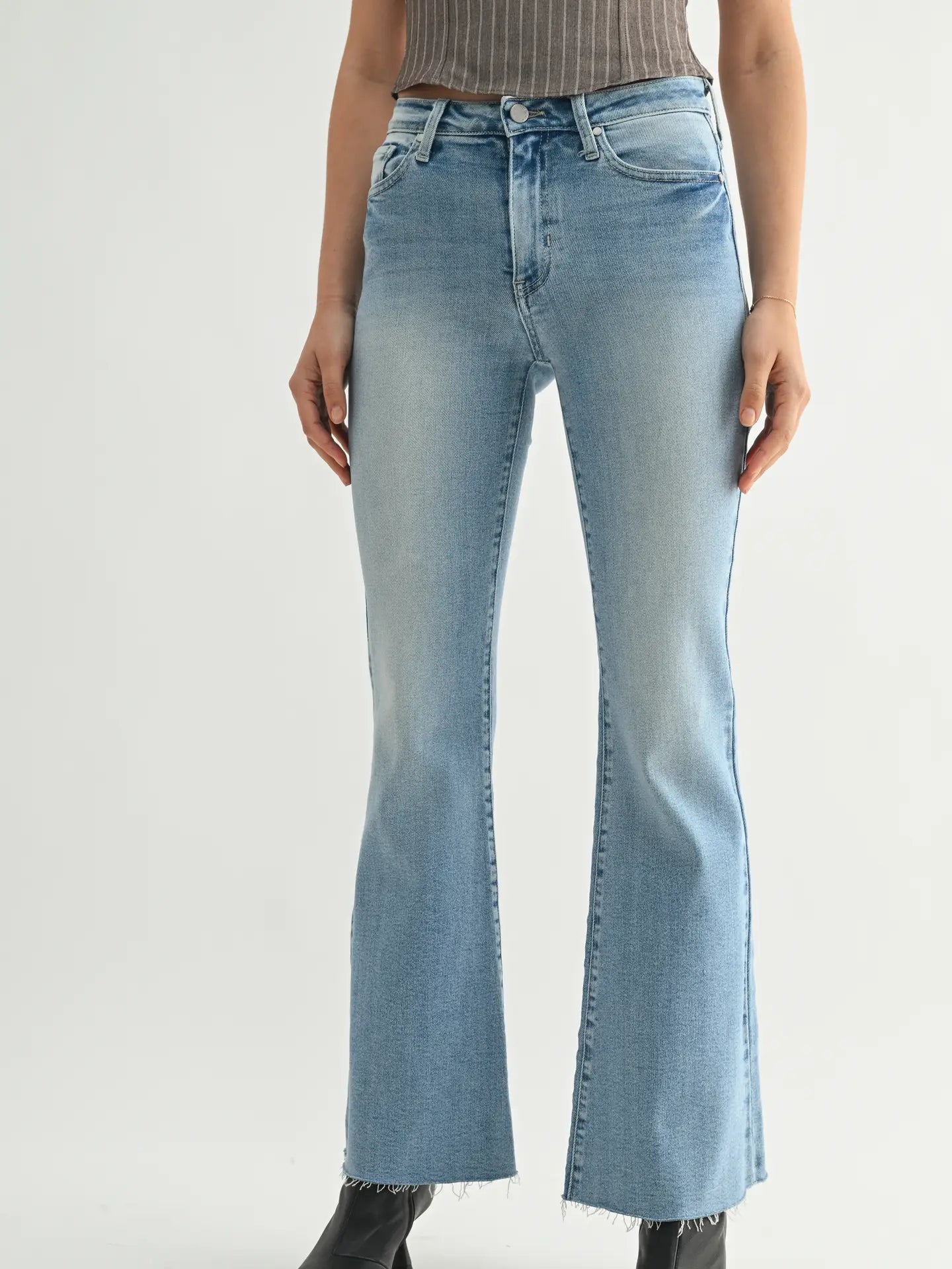 Light blue flared jeans worn by a person on a white background