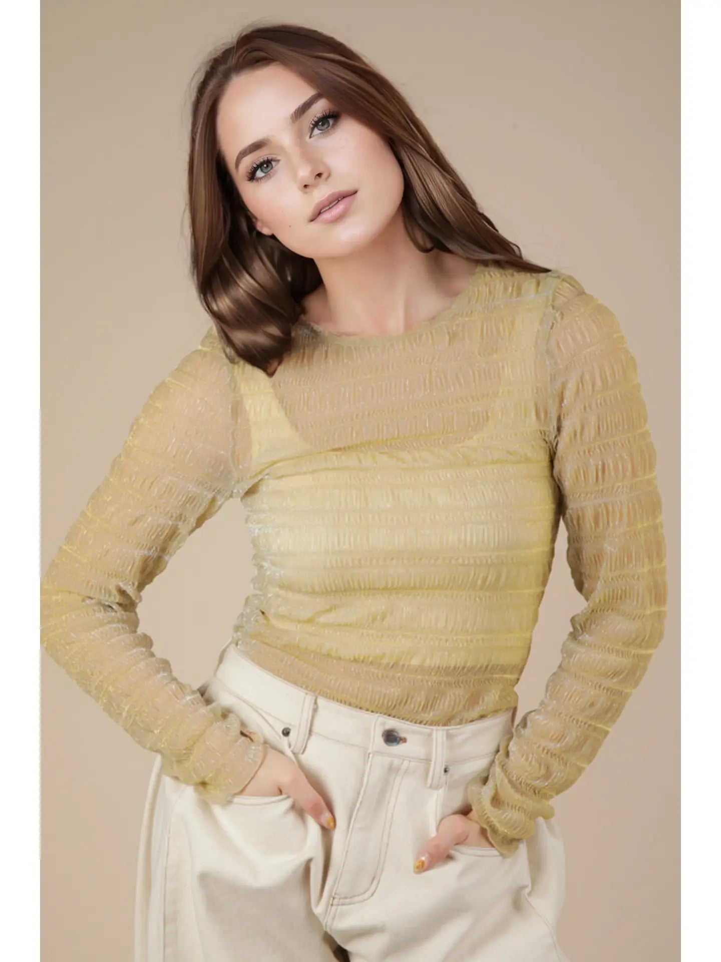 Front view: Model wearing champagne sheer lurex long-sleeve fitted top with crew/mock neck; subtle sparkle visible.