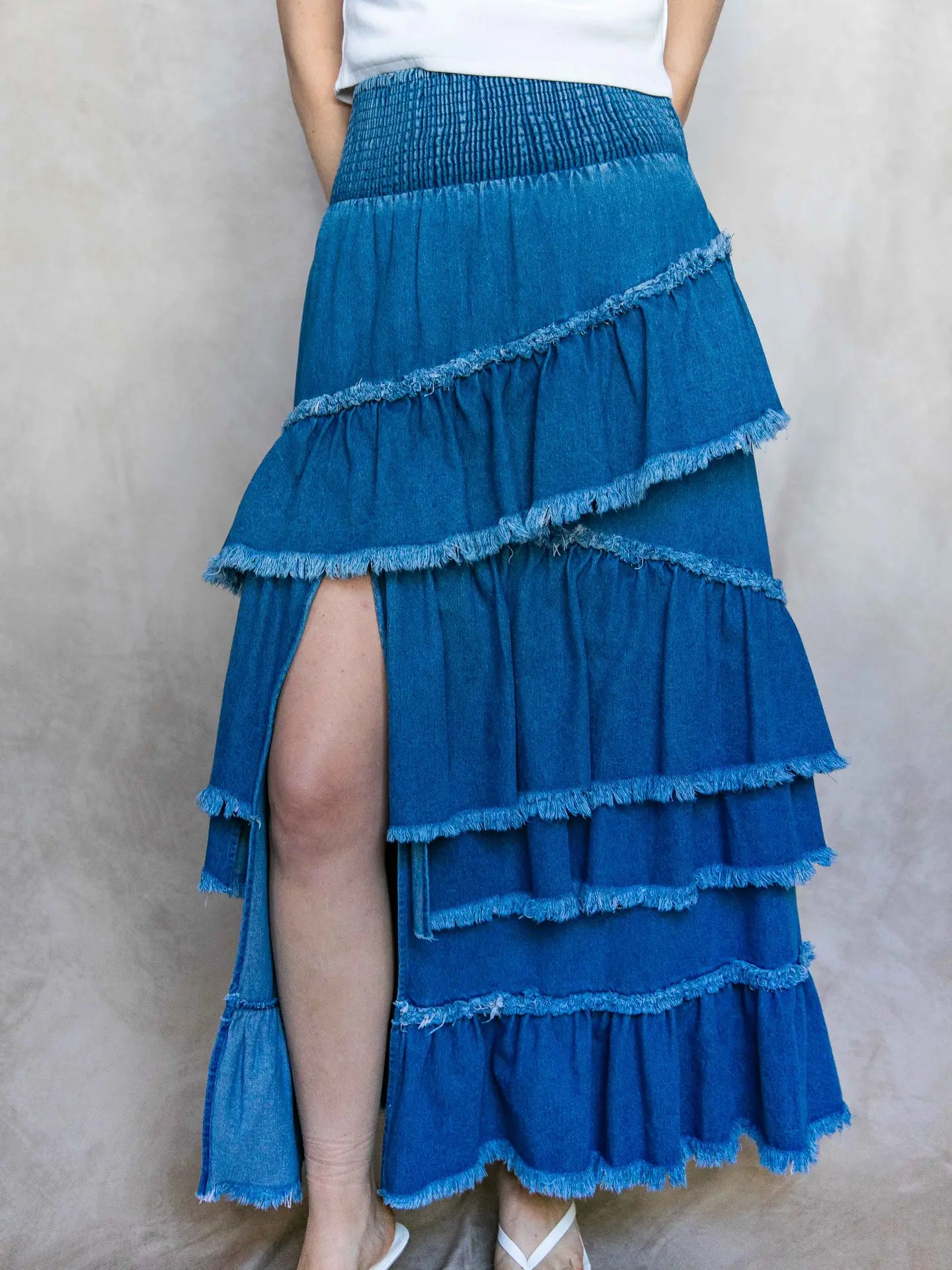 Blue tiered skirt worn by a person on a plain background