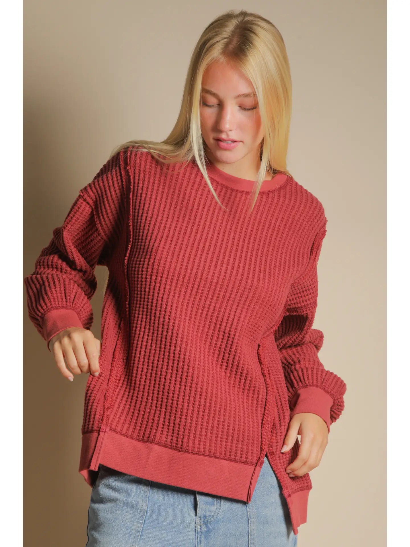 Front view of burgundy oversized waffle knit top with round neck and drop shoulders.