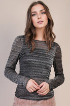 Front view: Model wearing a black sheer lurex mesh long-sleeve top with silver metallic threads, crew neck, fitted silhouette.