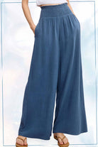 Blue wide-leg pants worn by a person on a light blue background