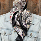 Patterned scarf draped over a denim jacket against a wooden background