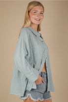 Side angle showing relaxed fit and side slit on sky blue gauze top