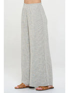 Light gray pin stripped pants worn with elastic  waist by a person 
