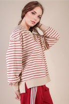 Side view: “Side angle of striped oversized knit top highlighting drop shoulder sleeve, side slit at ribbed hem, and relaxed boxy fit.”