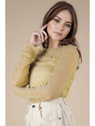 Front view: Model wearing champagne sheer lurex long-sleeve fitted top with crew/mock neck; subtle sparkle visible.