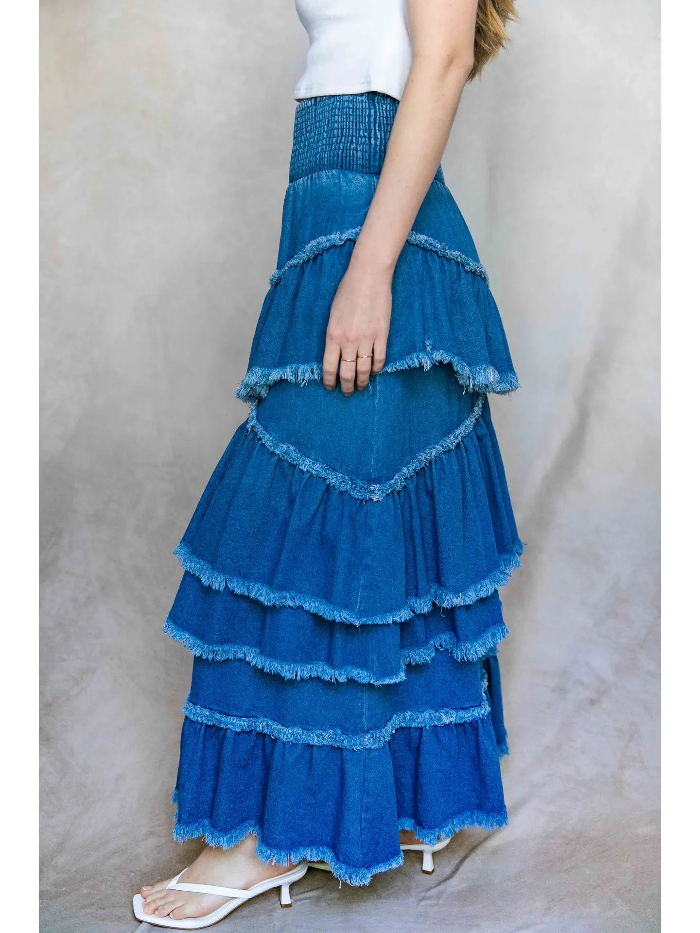 Blue tiered skirt worn by a person on a plain background