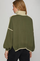 Back of sweater view Person wearing a green sweater with white trim and collar