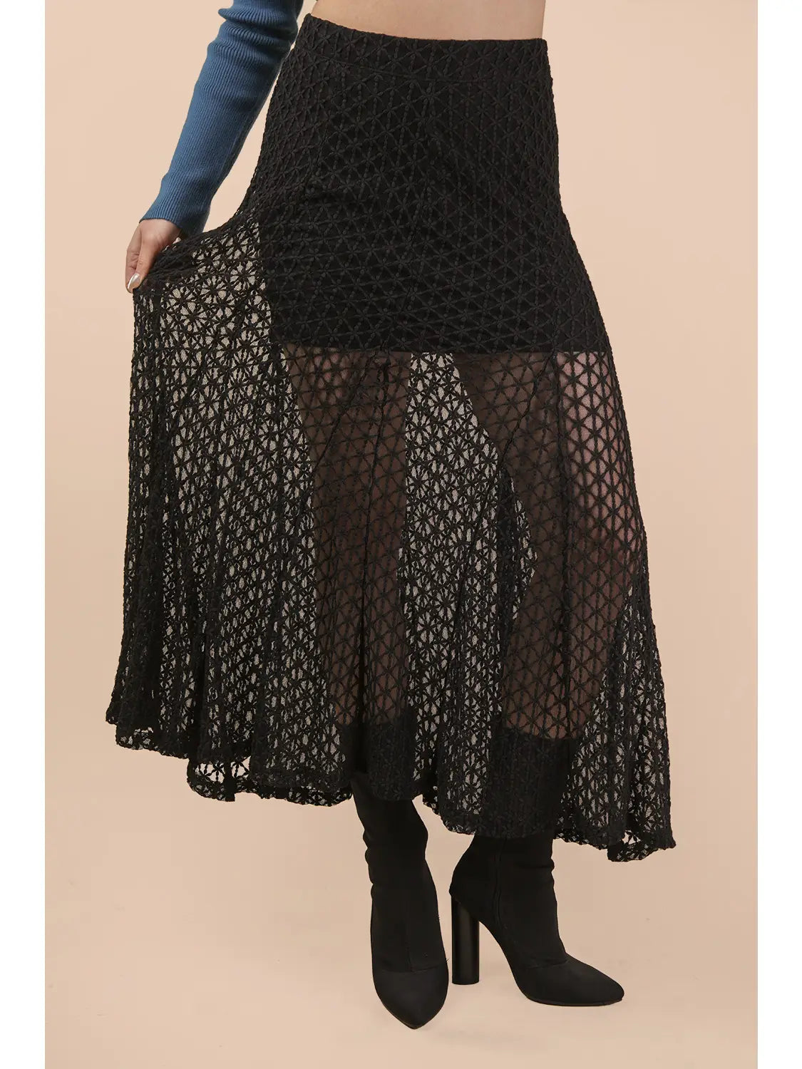 Black lace skirt worn by a person on a beige background