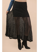 Black lace skirt worn by a person on a beige background