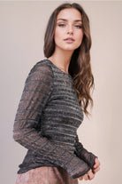 Side view: Profile of the black silver-thread lurex top highlighting the sheer sleeves and body-hugging fit.