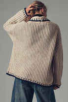 Back of Person wearing a chunky knit sweater with a gray background