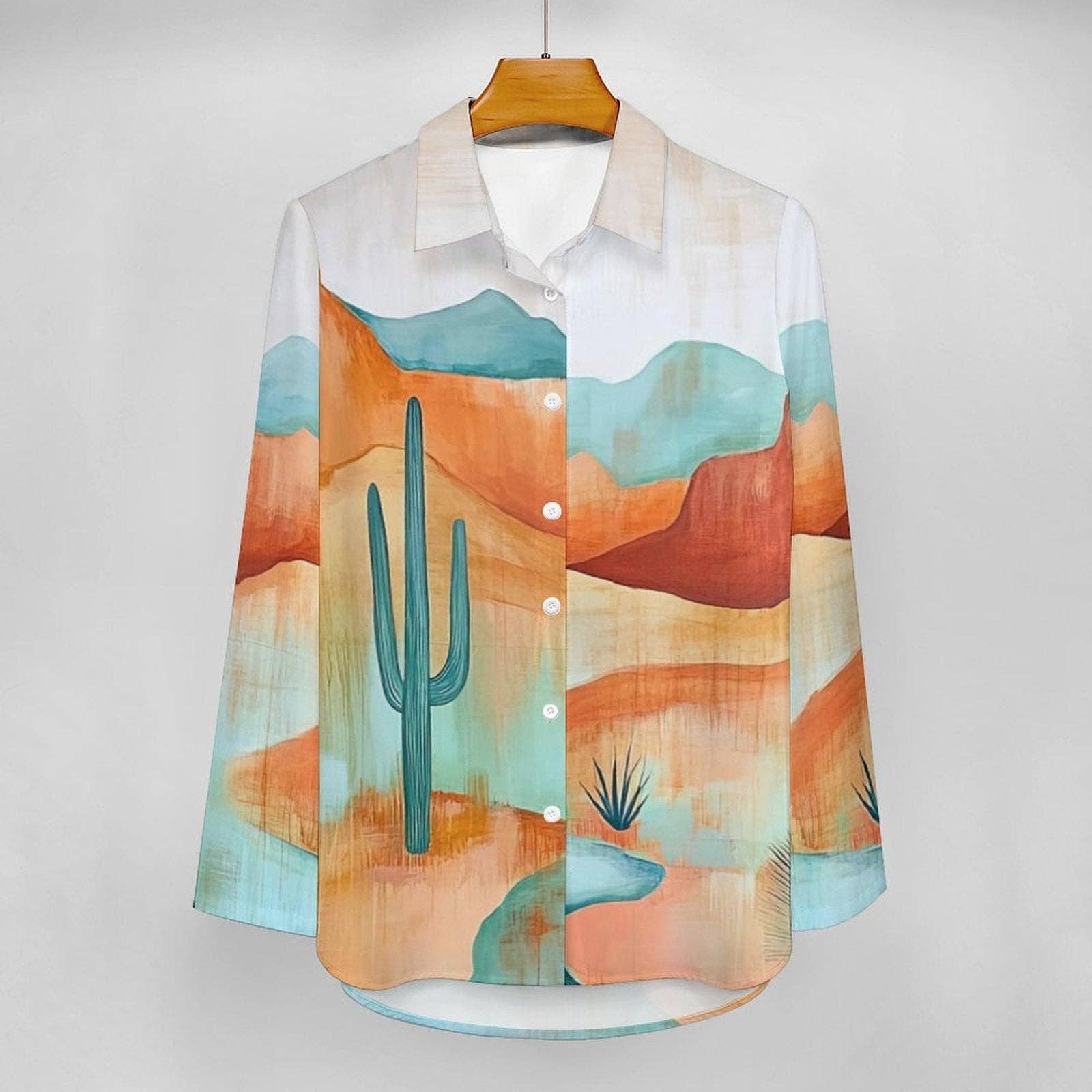 Colorful shirt with desert landscape design on a hanger against a white background