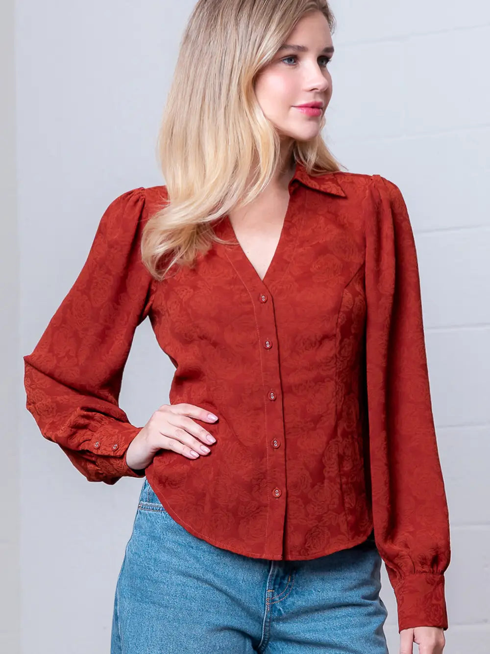 Front view of rust Western-inspired embossed blouse showing tailored waist and button front.