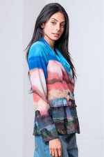 Woman wearing a colorful jacket with a plain background