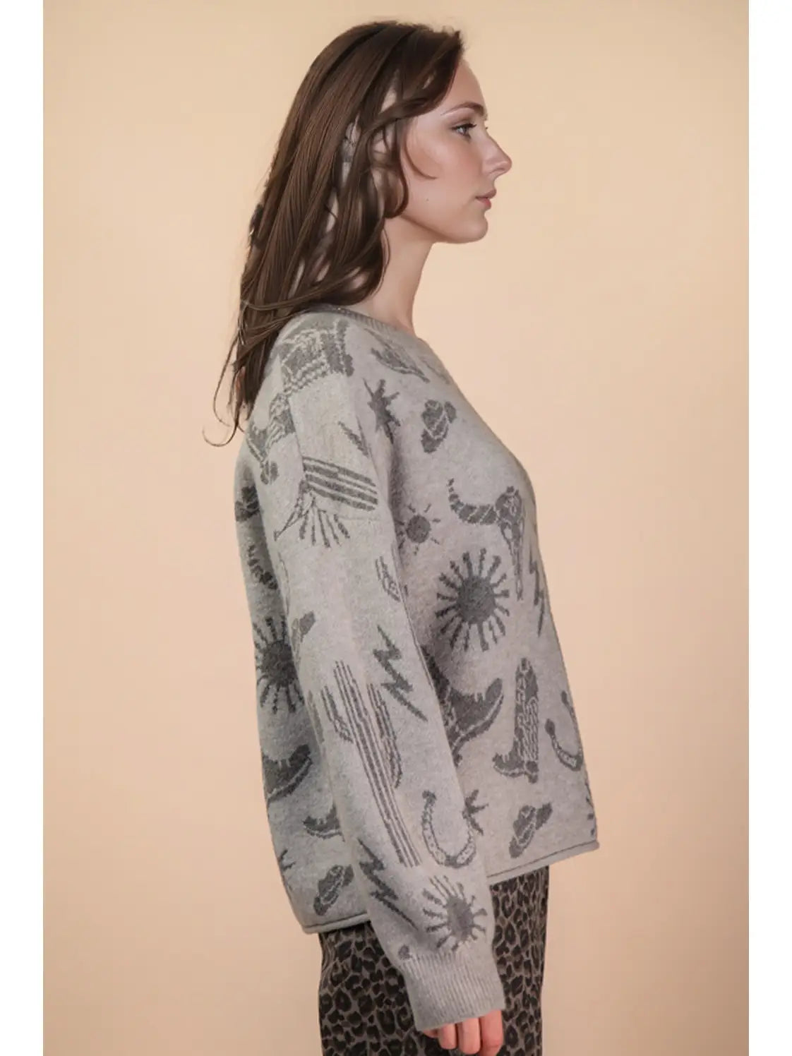 Side angle showing relaxed drape and long sleeves on grey western graphic sweater