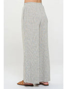 Light gray pin stripped pants worn with elastic  waist by a person 