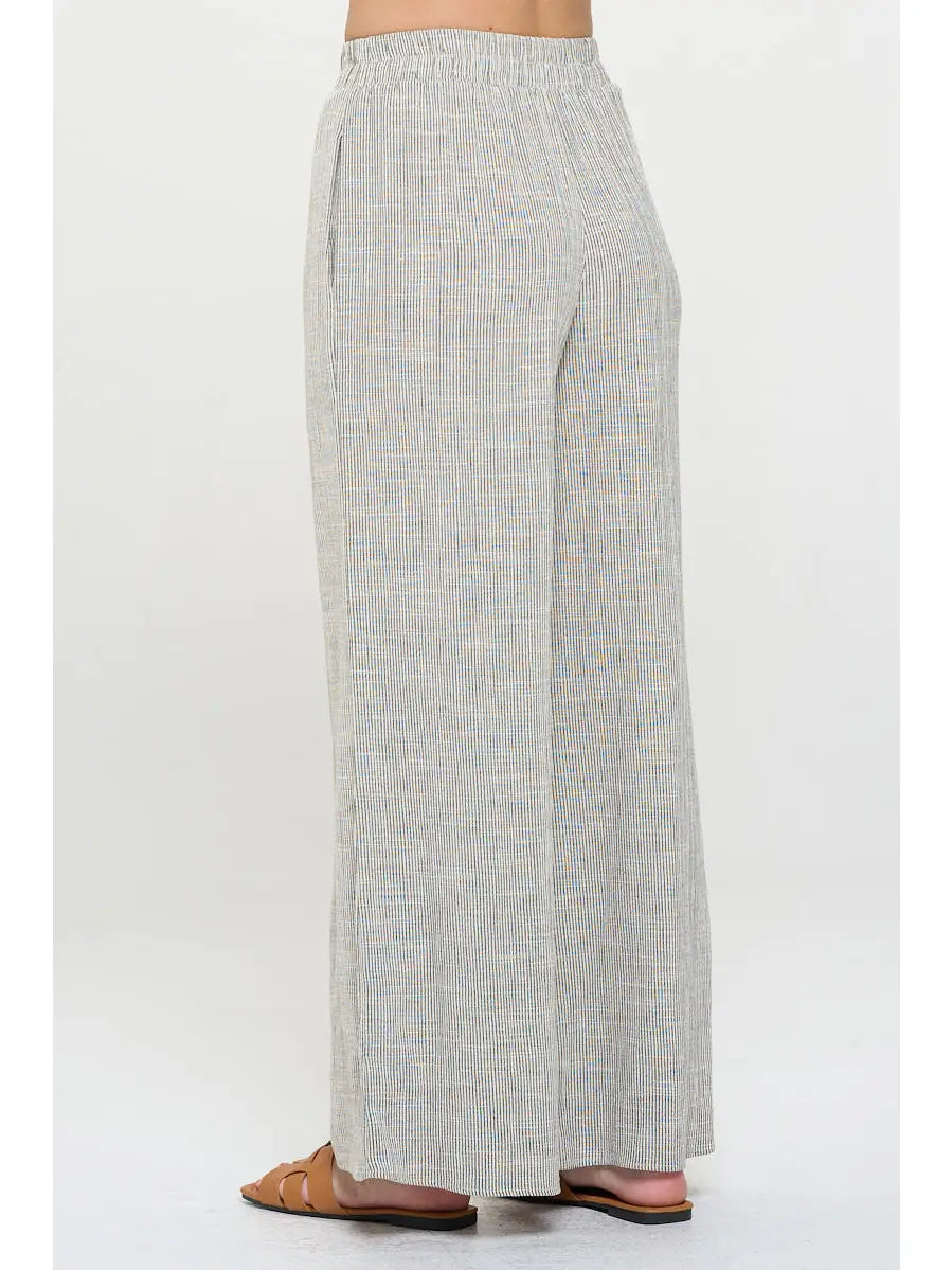 Light gray pin stripped pants worn with elastic  waist by a person 