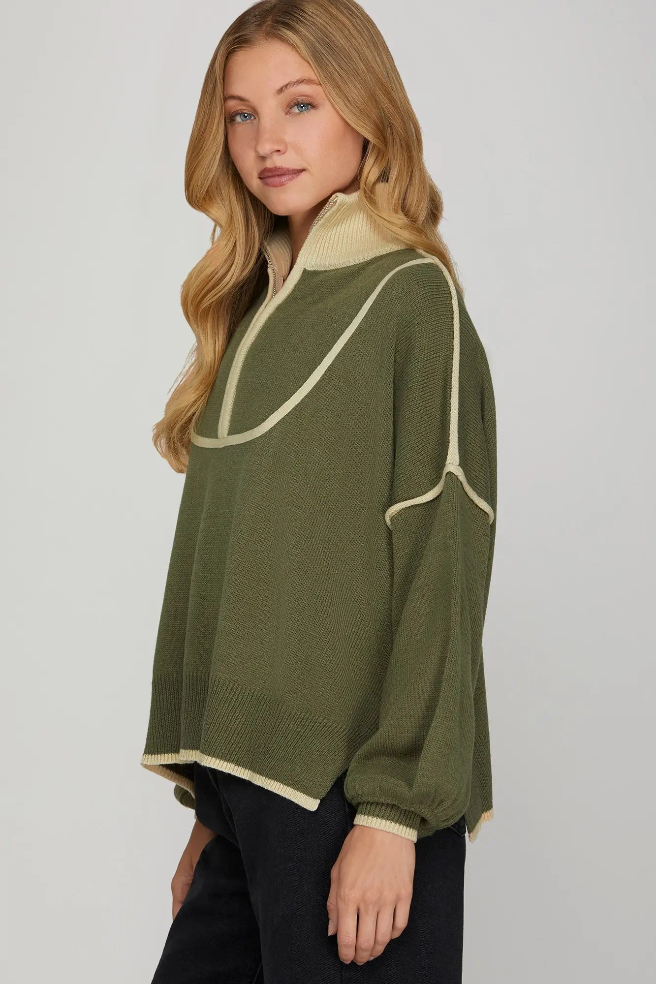Front view Woman wearing a green sweater with white trim  Half Zip