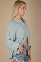 Side angle showing relaxed fit and side slit on sky blue gauze top