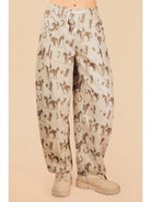 Pants with horse pattern worn by a person on a beige background