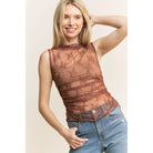 Woman wearing a brown lace top sleeveless high neck and light blue jeans indoors.